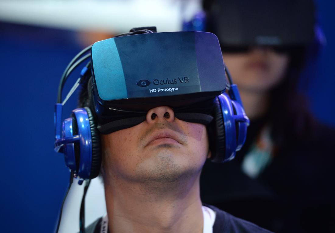 An attendee wears an Oculus Rift HD virtual reality head-mounted display at he plays EVE: Valkyrie, a multiplayer virtual reality dogfighting shooter game, at the Intel booth at the 2014 International CES, January 9, 2014 in Las Vegas, Nevada. AFP PHOTO /ROBYN BECK (Photo credit should read ROBYN BECK/AFP/Getty Images)